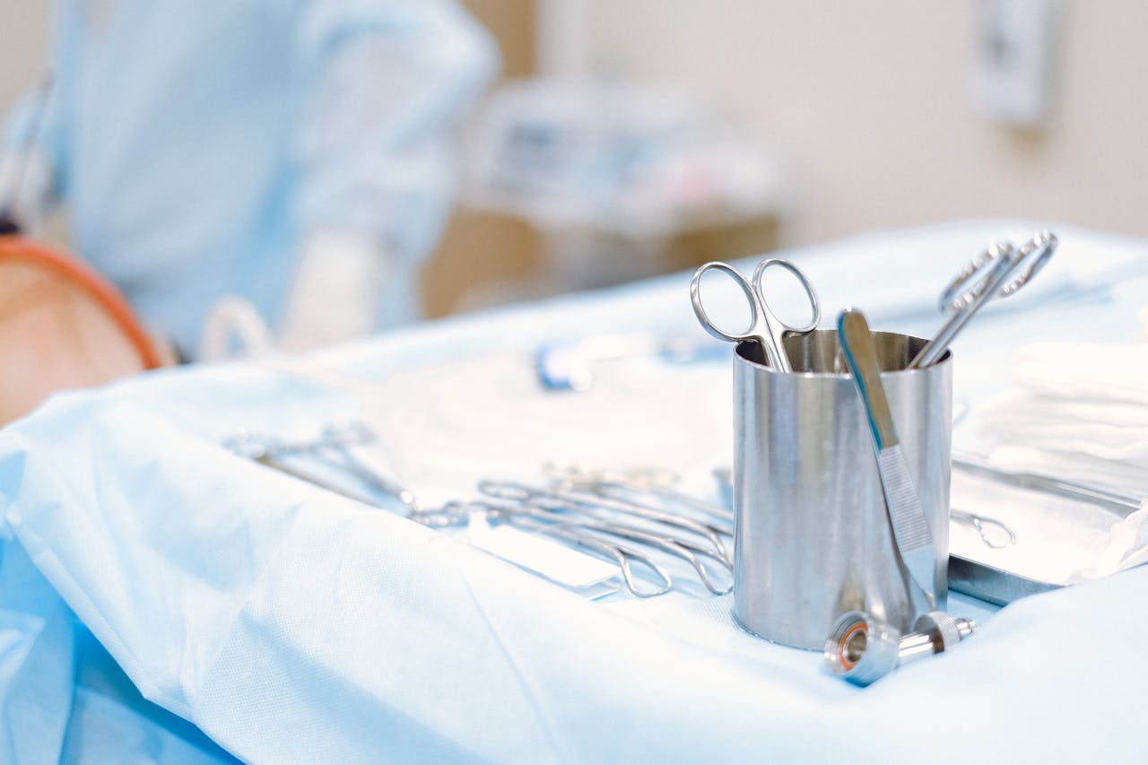 A close-up of surgical instruments on a sterile table in an operating room, emphasizing precision and care.