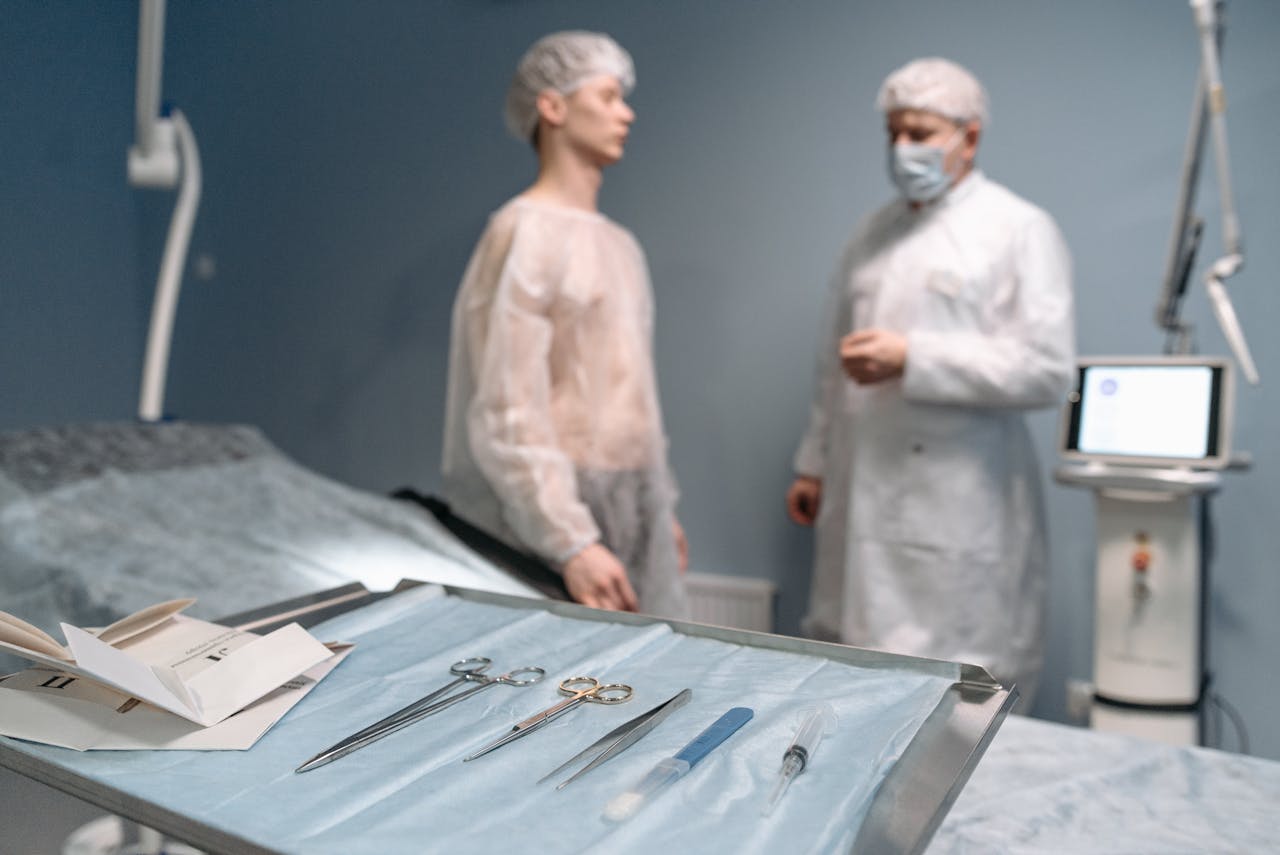 Surgical tools arranged on tray in operating room with doctors in the background.