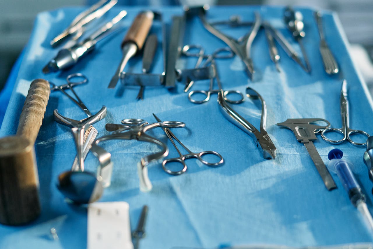 Close-up of various sterilized surgical tools laid out on a blue surface, ready for medical procedures.